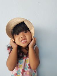 Portrait of smiling girl against wall