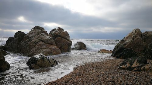 Rocks on beach against sky