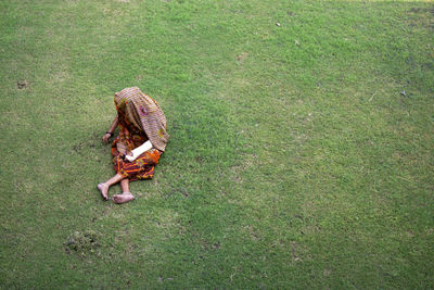 Woman weeding grass by hand - while one hand is injured