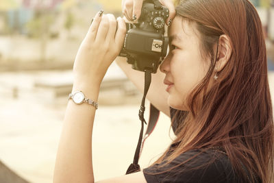 Side view of girl photographing