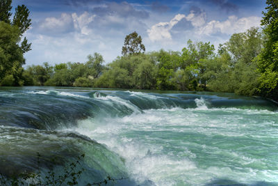Scenic view of waterfall against sky