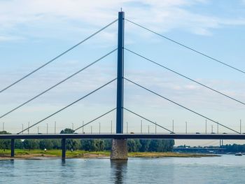 Suspension bridge over river against sky