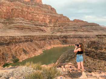 Full length of woman on rock by mountain