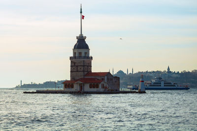 View of building by sea against sky in city