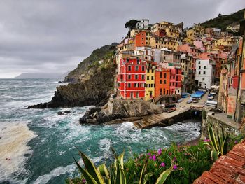 Scenic view of sea by buildings against sky