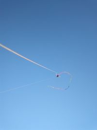 Low angle view of vapor trail against clear blue sky