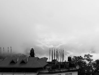 High section of building and trees against sky