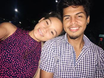 Portrait of smiling young couple at night
