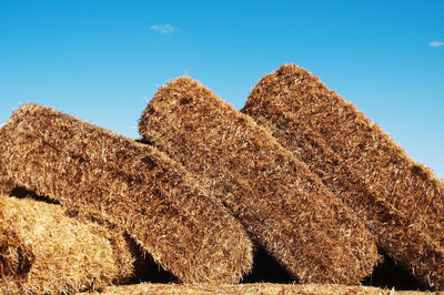 Low angle view of hay stakcs against clear sky