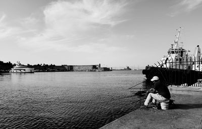 Rear view of woman standing on sea against sky