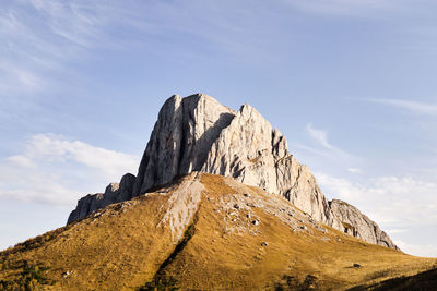 Low angle view of rocky mountain against sky