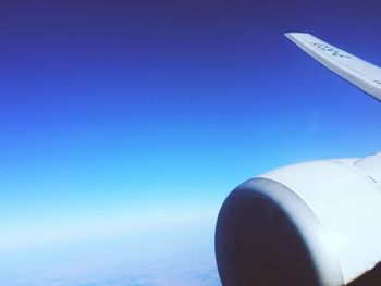 Low angle view of cropped car against blue sky