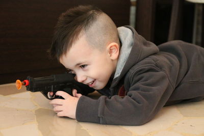 Portrait of boy with baby lying on floor