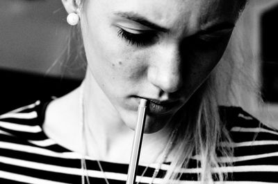 Close-up of woman touching lips with pen at home