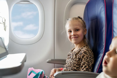 Portrait of happy boy sitting in airplane