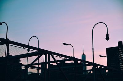 Silhouette of street lights in city at sunset