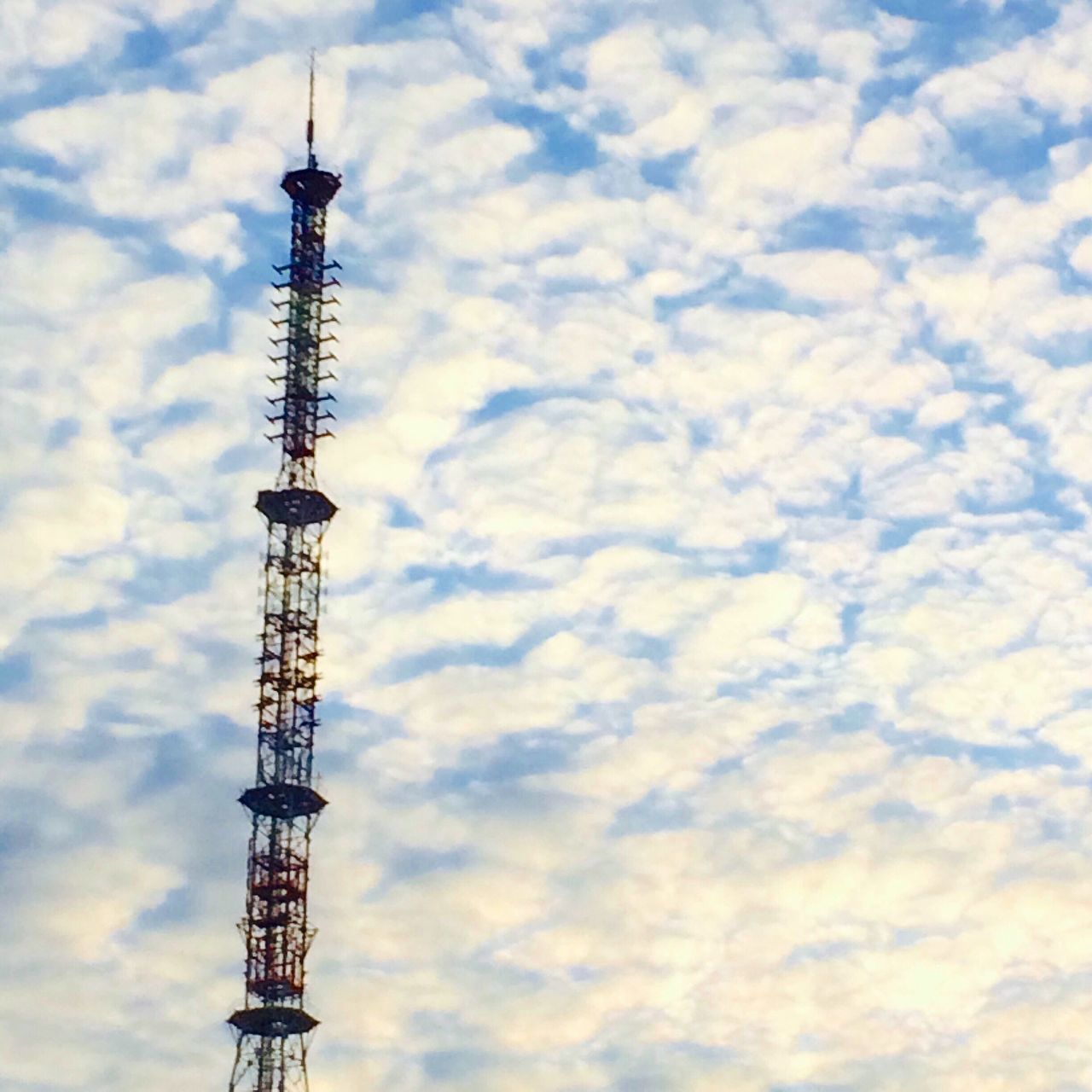 sky, low angle view, cloud - sky, tall - high, tower, built structure, architecture, communications tower, cloudy, international landmark, building exterior, travel destinations, cloud, famous place, tourism, capital cities, city, travel, development, crane - construction machinery