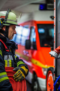 Firefighter holding hose at fire station