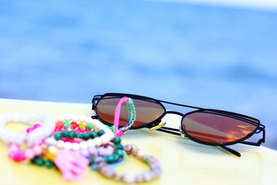 Sunglasses and bead jewelry on table