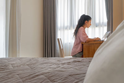 Side view of woman lying on bed