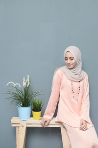 Woman with potted plants against white background