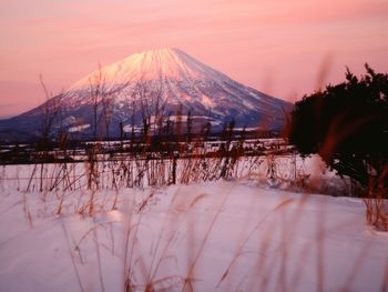 Scenic view of snow covered mountains against sky during sunset