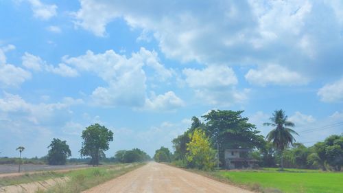 Road amidst trees against sky