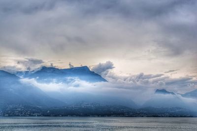 Scenic view of sea and cloud mountains against sky before thunderstorm