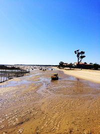 Scenic view of beach against clear blue sky