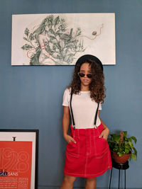 Portrait of smiling woman standing against wall