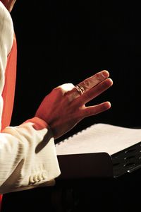 Close-up of hand holding paper with text on table