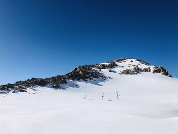 Scenic view of snowcapped mountains against clear blue sky