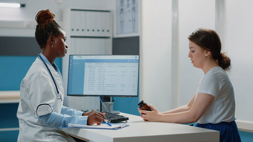 Female doctor examining patient in clinic