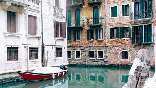 Rowboat moored in channel against old building