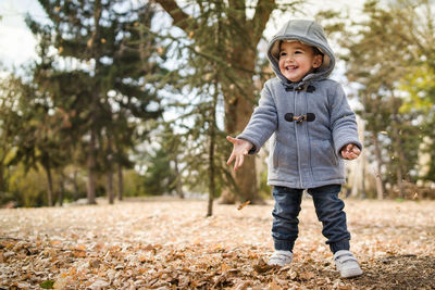 Portrait of smiling boy standing on tree