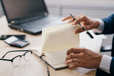 Midsection of man using laptop on table