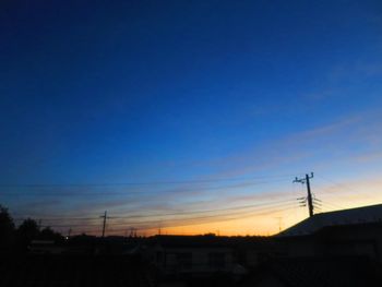 Silhouette houses against sky during sunset