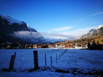 Scenic view of snow covered mountains against blue sky