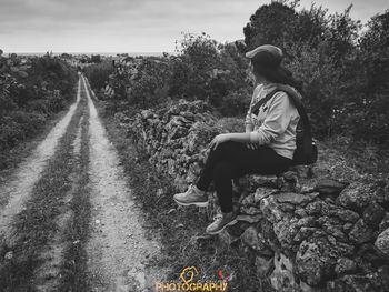 Full length of man sitting on rock