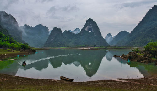 Scenic view of lake and mountains against sky