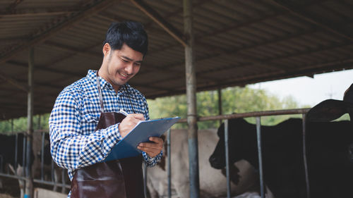 Side view of young man working in pen