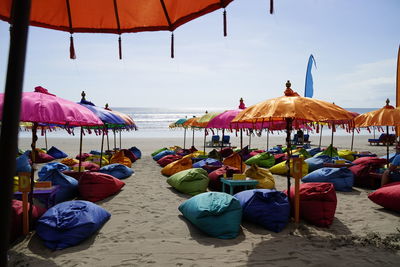 Lounge chairs and umbrellas on beach against sky