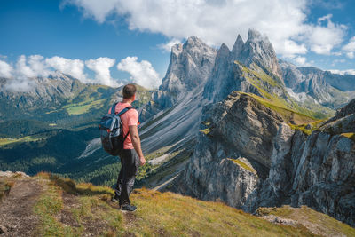 Full length of man looking at mountains against sky