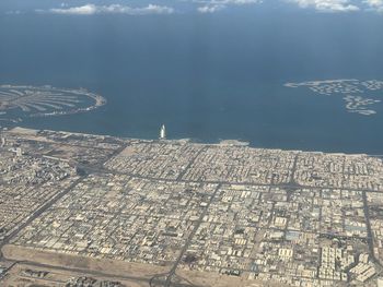 High angle view of city by sea against sky