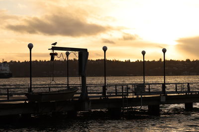 Pier over sea against sky during sunset