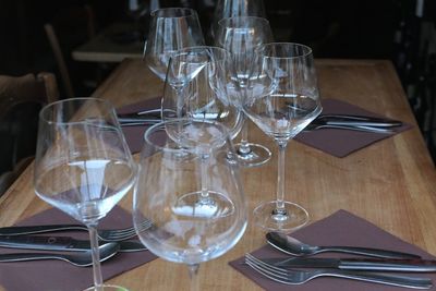 Close-up of empty wineglasses and place settings on table at restaurant