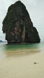 Rock formation on beach against sky