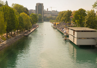 Scenic view of river in city against clear sky