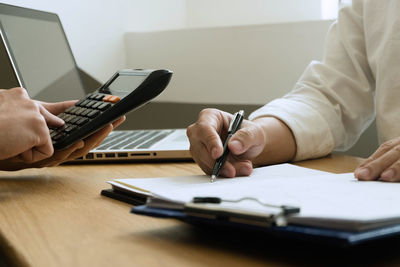 Midsection of man using laptop on table