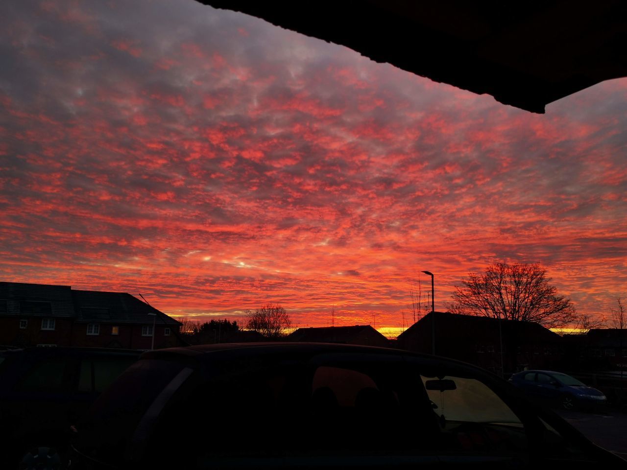 SILHOUETTE CARS AGAINST ORANGE SKY